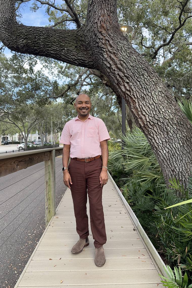 Martial smiling on a tree-lined boardwalk in Clearwater